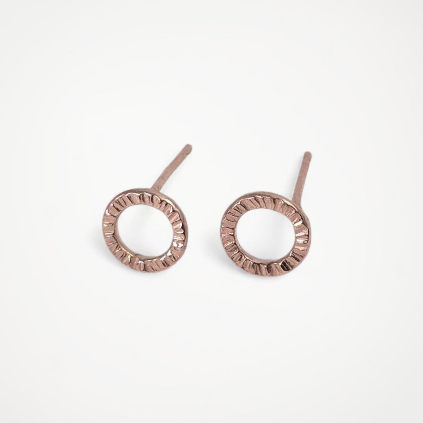 Pair of rose gold stud earrings on a white background