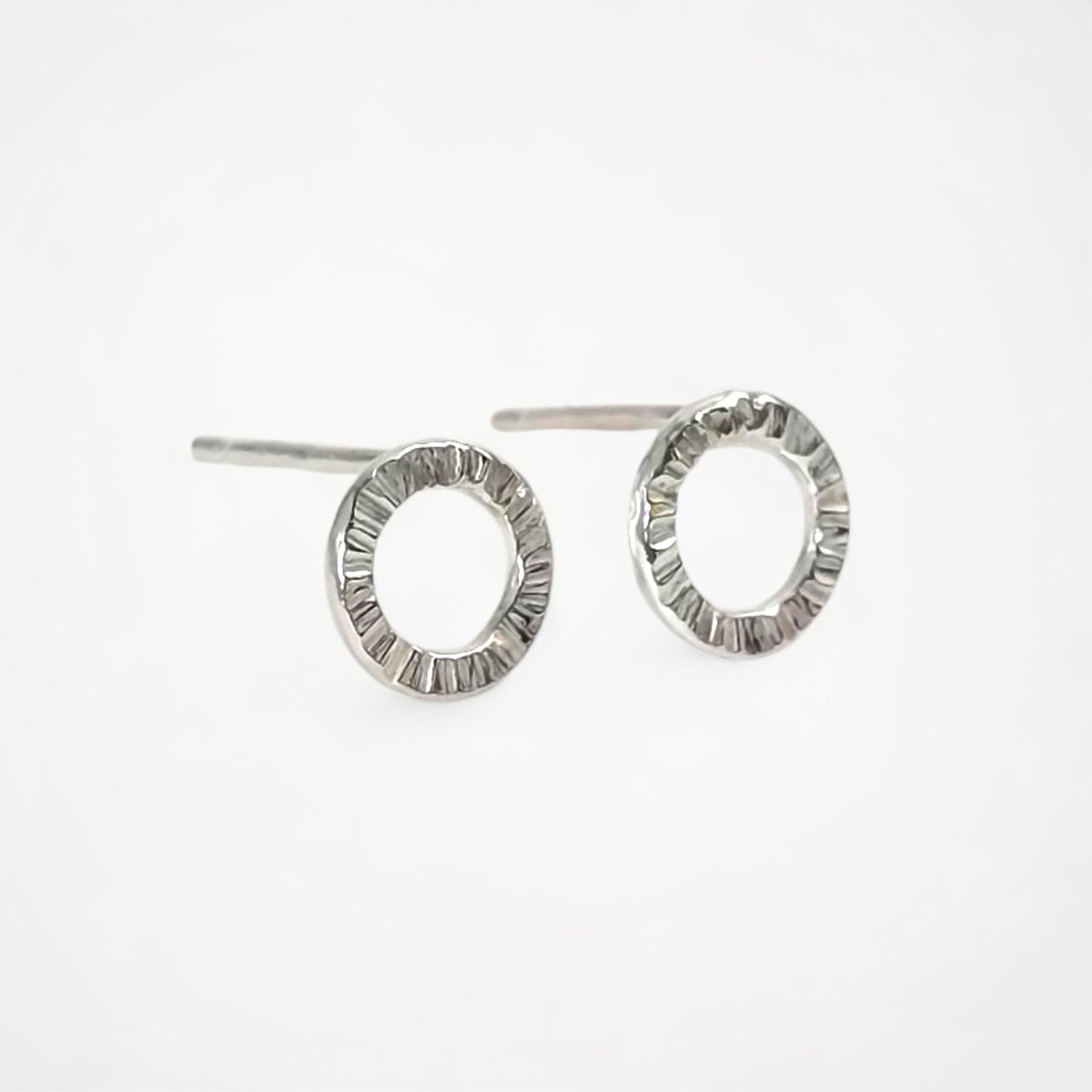 Pair of silver stud earrings on a white background