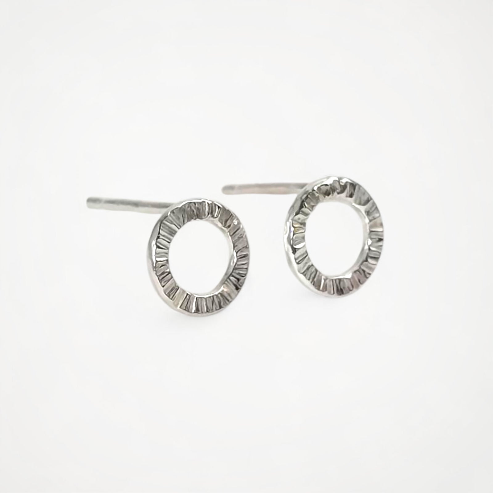 Pair of silver stud earrings on a white background