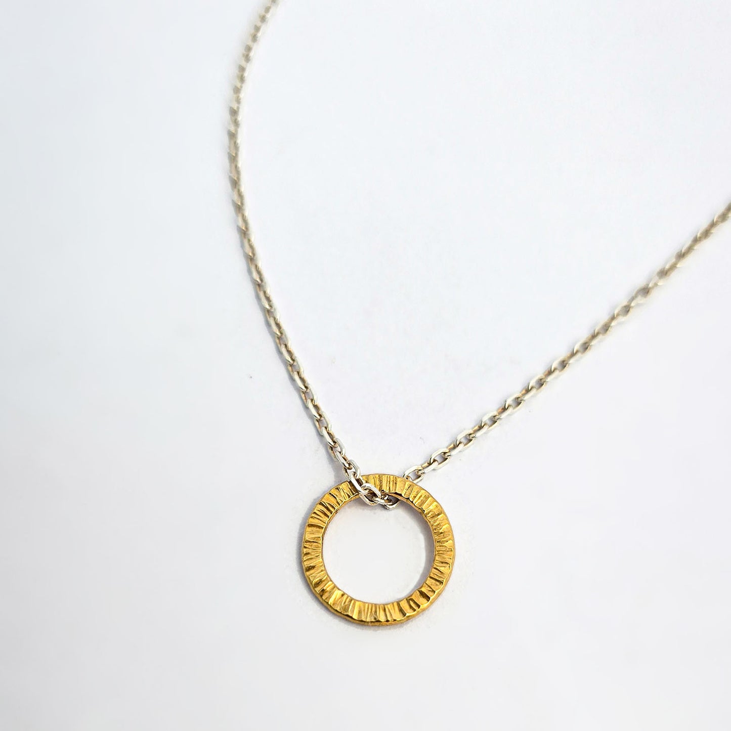 Textured circular pendant with hand-hammered surface, finished in yellow gold vermeil.