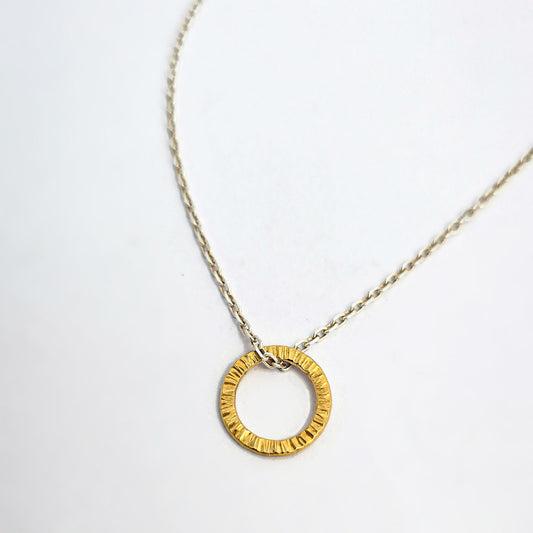 Textured circular pendant with hand-hammered surface, finished in yellow gold vermeil.