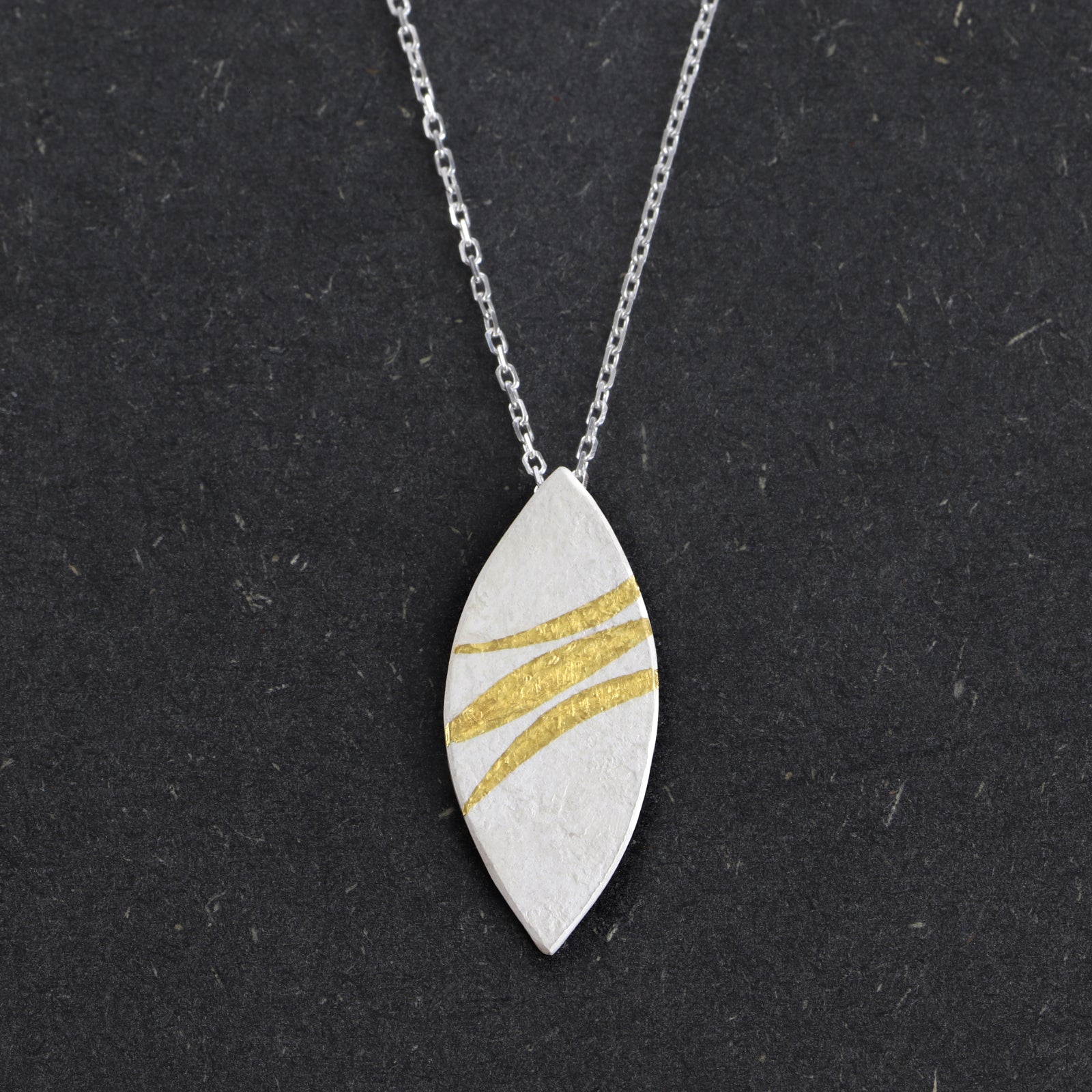 Handcrafted sterling silver marquise pendant with 24ct gold Keum-Boo ribbons by Jenny Holdsworth