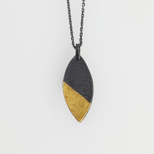 A marquise shaped pendant with a golden tip, hand made by Jenny Holdsworth