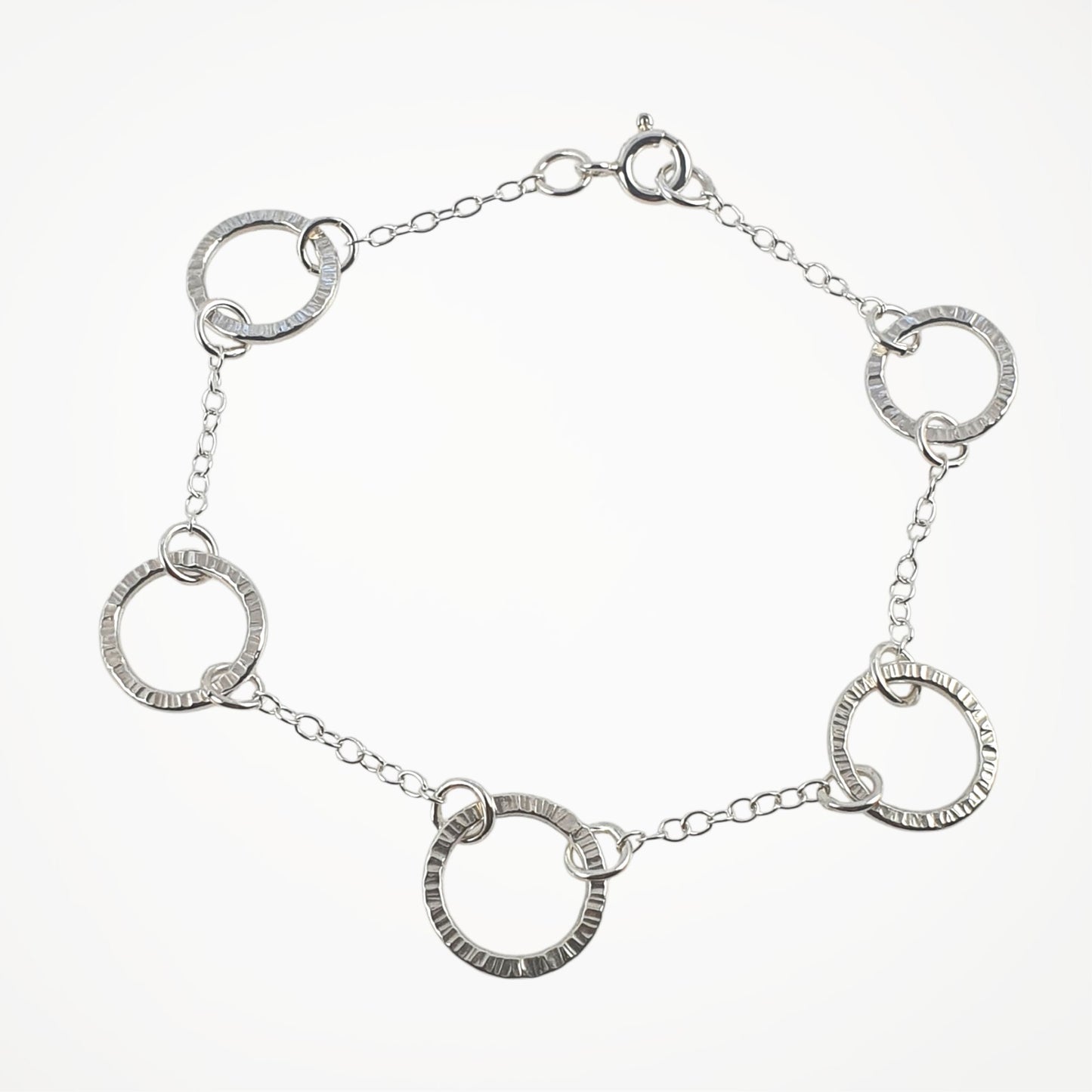 Silver bracelet with interlocking circular links on a white background