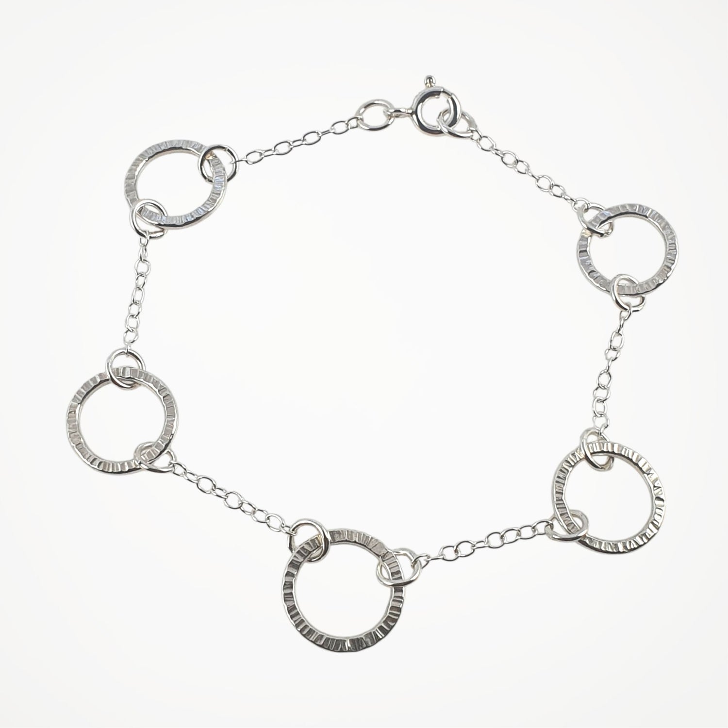 Silver bracelet with interlocking circular links on a white background
