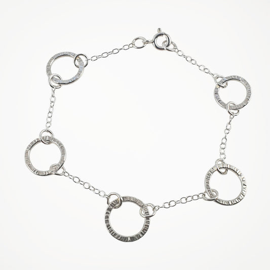 Silver bracelet with interlocking circular links on a white background
