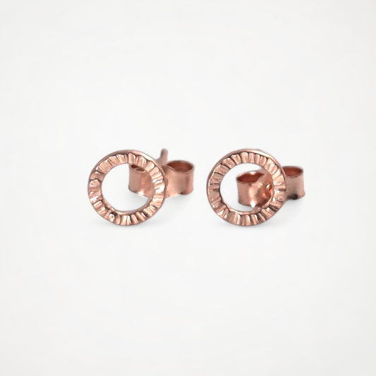 Pair of rose gold stud earrings on a white background