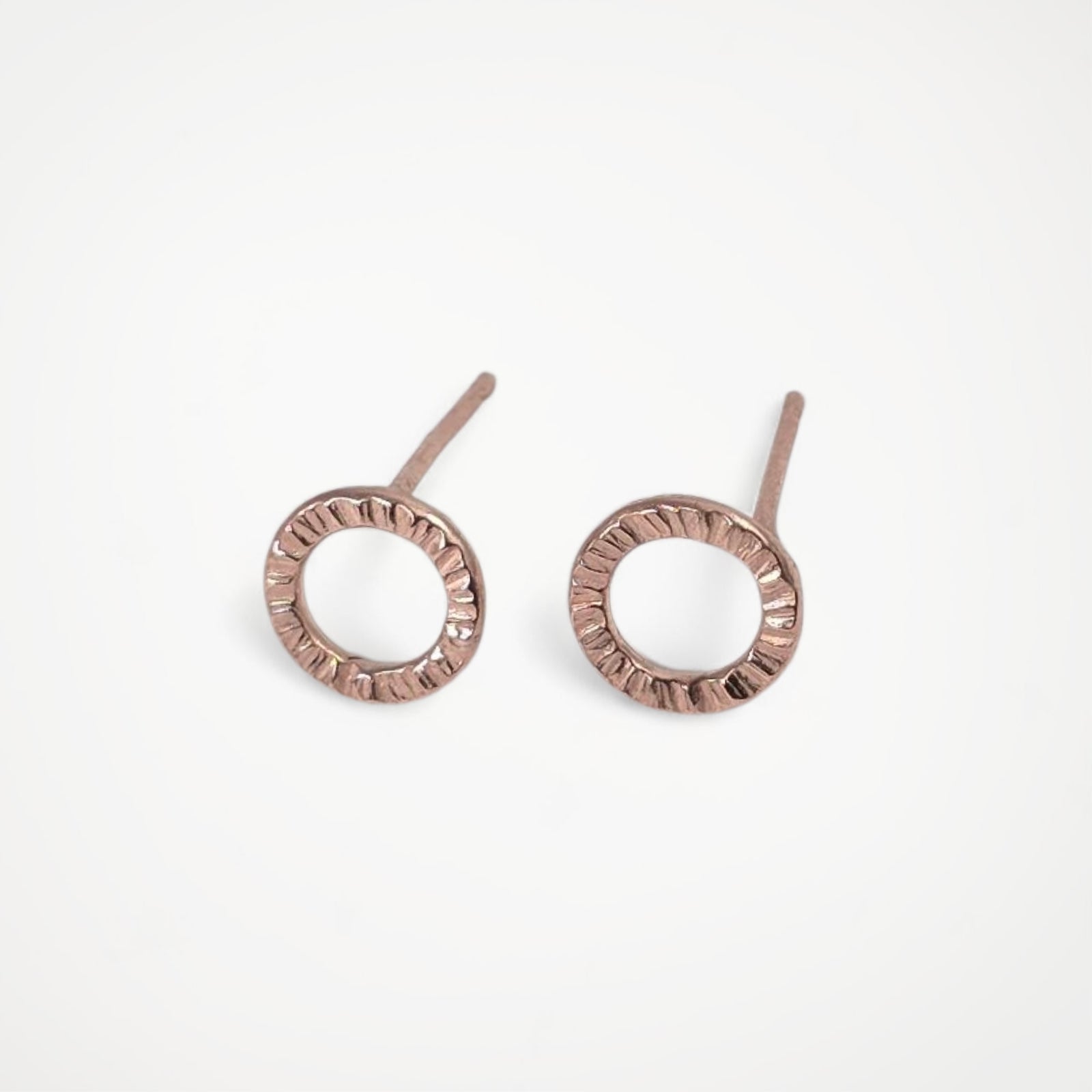 Pair of rose gold stud earrings on a white background