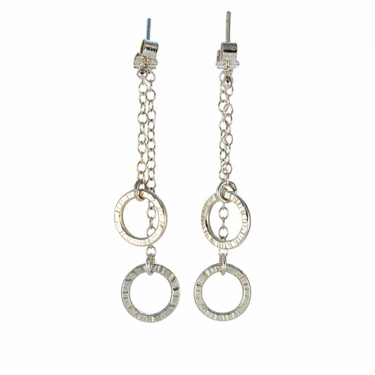 Sterling silver double circle drop earrings with hand-textured rings suspended from fine chain.